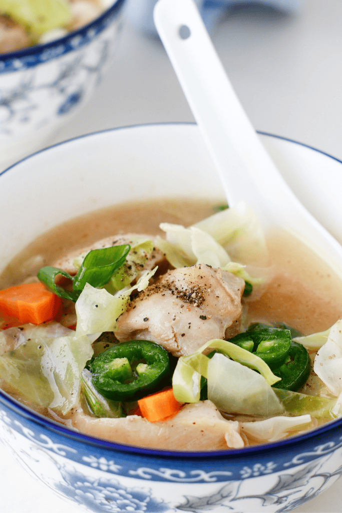 Close-up of keto chicken cabbage soup showing tender chicken, cabbage, and jalapeños in a flavorful broth.