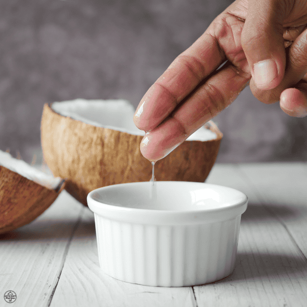 Coconut oil being scooped with fingers, showing a keto-approved fat used in the 2 2 2 2 rule.