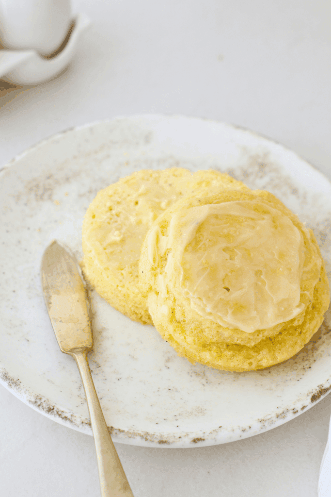 Soft 90 second keto bread sliced and topped with butter, showing a fluffy crumb and tender texture, served on a plate as an easy low carb microwave bread made with almond flour.