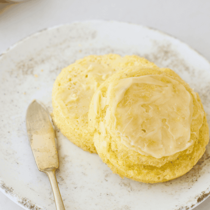 Soft 90 second keto bread sliced and topped with butter, showing a fluffy crumb and tender texture, served on a plate as an easy low carb microwave bread made with almond flour.