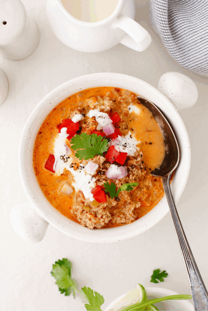 A comforting beef soup perfect for keto dinner, served hot in a white bowl with a spoon alongside.